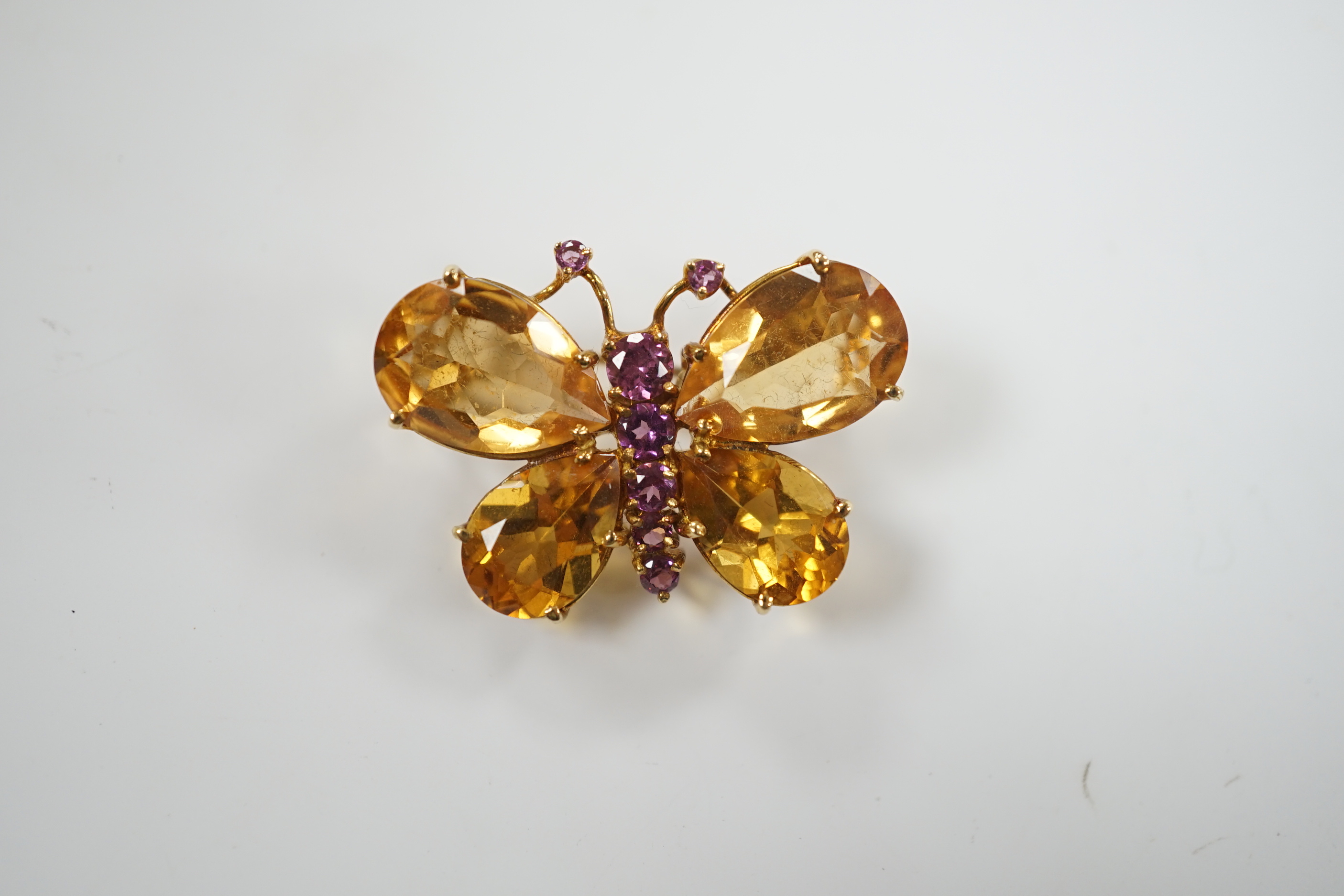 A modern Italian 750 yellow metal, four stone citrine and graduated seven stone pink sapphire set butterfly brooch, width 32mm, gross weight 8.1 grams.